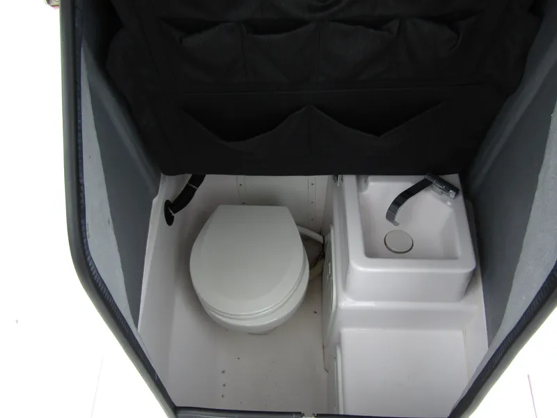 Slide: The Image of 2022 Axopar 22 T-Top boat interior with compact toilet and sink. - 10