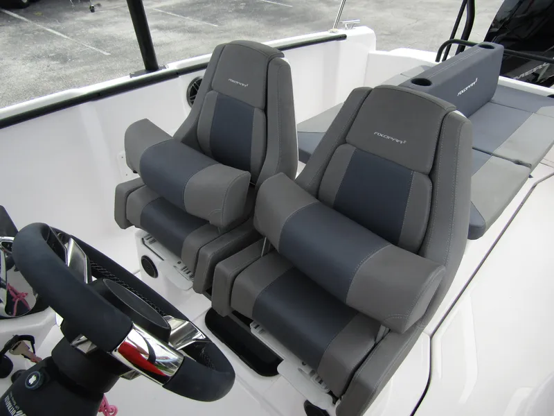 Slide: The Image of 2022 Axopar 22 T-Top boat interior with dual gray seats and steering wheel. - 11