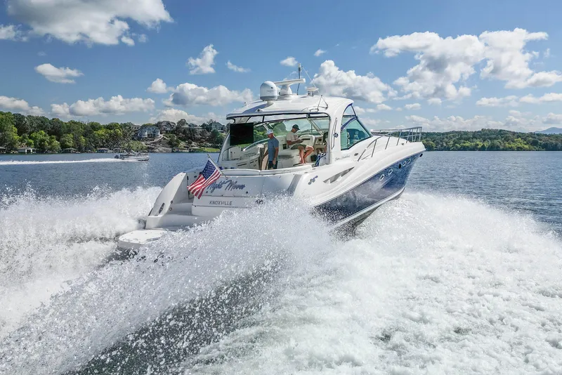 Slide: The Image of 2005 Sea Ray 500 Sundancer cruising on a sunny lake with lush green shoreline. - 10