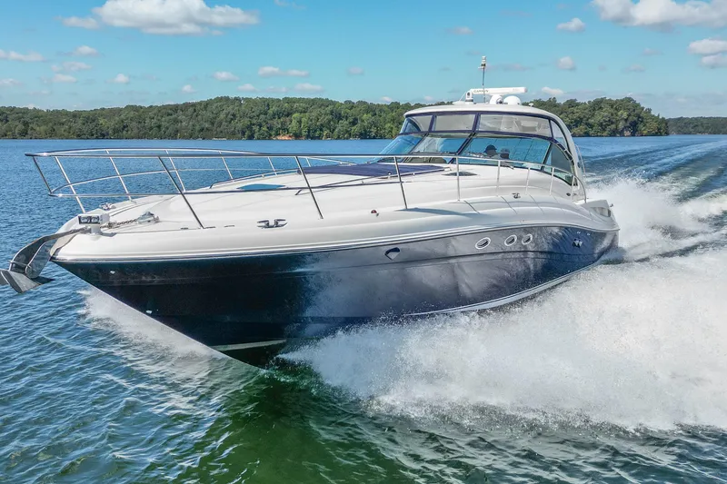 Slide: The Image of 2005 Sea Ray 500 Sundancer cruising on a lake under a clear blue sky. - 18