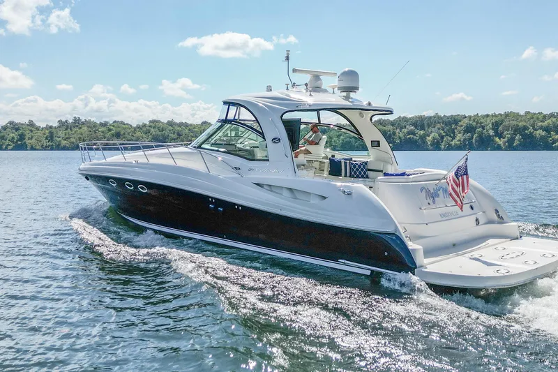 Slide: The Image of 2005 Sea Ray 500 Sundancer yacht cruising on a sunny lake with American flag. - 2