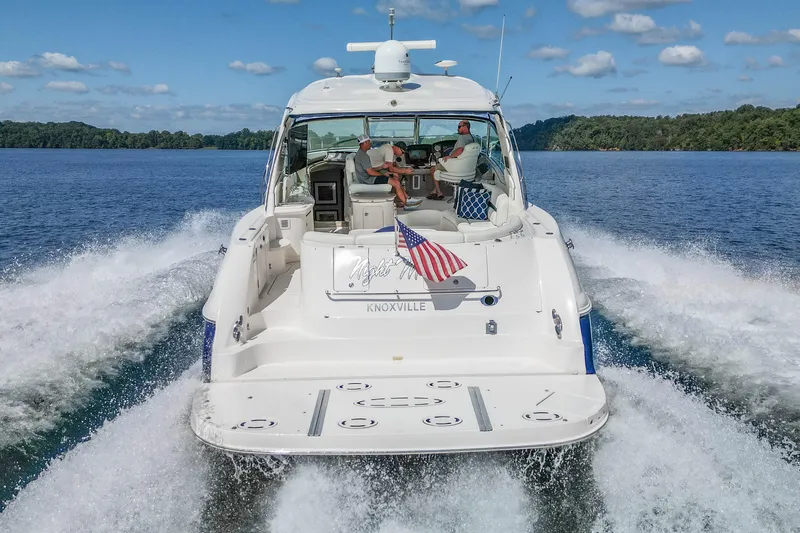 Slide: The Image of 2005 Sea Ray 500 Sundancer cruising on a lake, American flag displayed. - 21