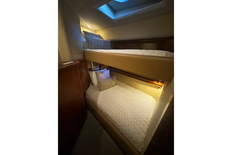 Slide: The Image of 2005 Sea Ray 500 Sundancer cabin with cozy bunk beds and soft lighting. - 46