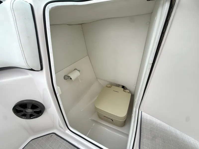 Slide: The Image of The image shows a compact boat toilet with a portable toilet and a toilet paper holder. - 26