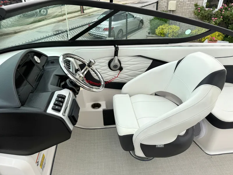 Slide: The Image of The image shows the cockpit of a 2022 Regal 23 OBX boat with a white captain's chair and modern helm. - 13