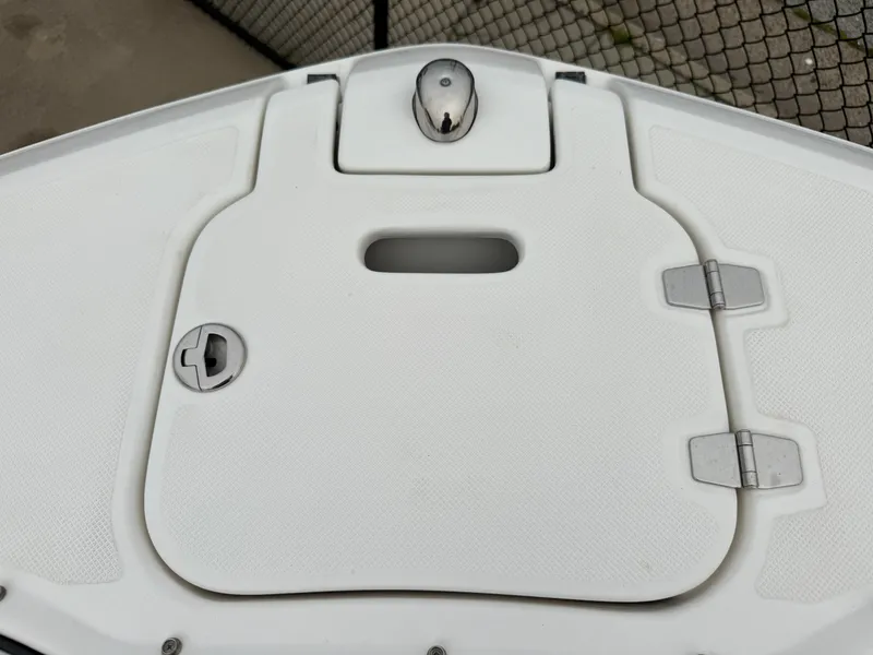 Slide: The Image of The image shows a white bow hatch of a Regal 23 OBX boat with metal fittings. - 18