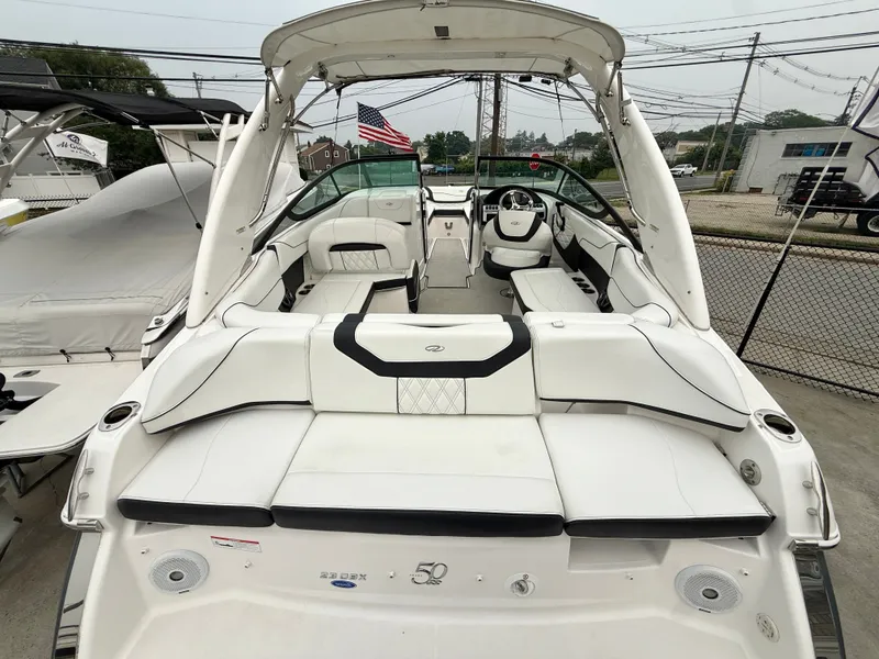 Slide: The Image of The image shows the cockpit of a 2022 Regal 23 OBX boat with white upholstery. - 2