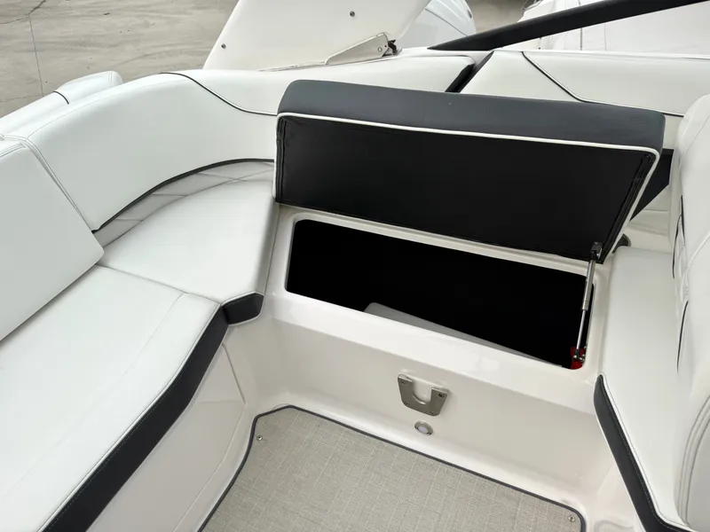 Slide: The Image of The image shows the seating area of a Regal 23 OBX boat with an open storage compartment. - 10