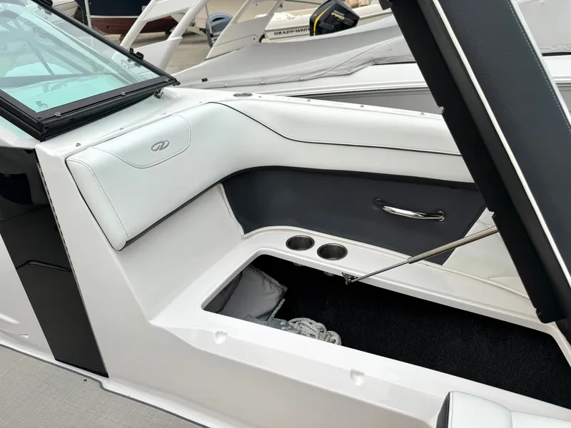 Slide: The Image of The image shows the interior of a 2022 Regal 23 OBX boat with white and black upholstery. - 24