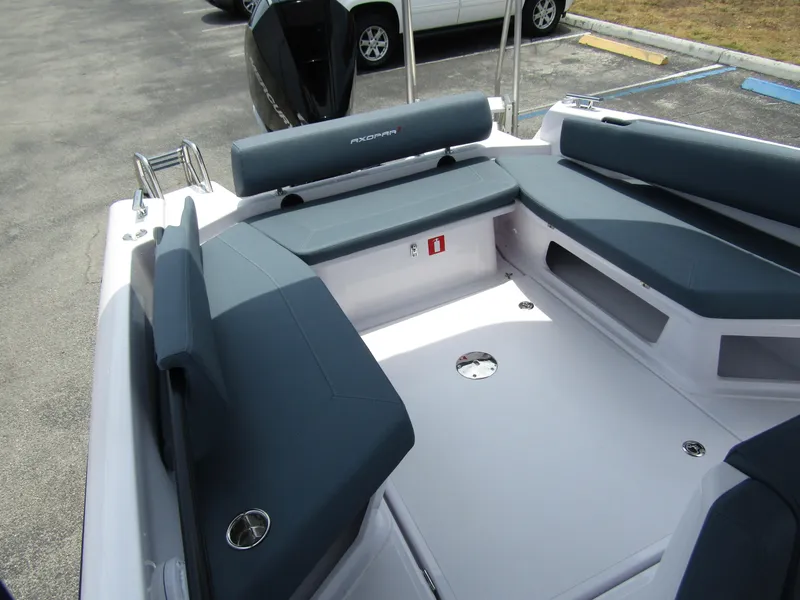 Slide: The Image of 2024 Axopar 25 Cross Top boat interior with cushioned seating and storage compartments. - 24
