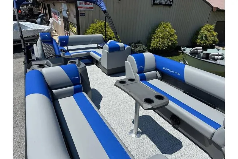 Slide: The Image of 2026 Bennington 23 SSB Swing Back Pontoon with blue and gray seating, docked outdoors. - 9
