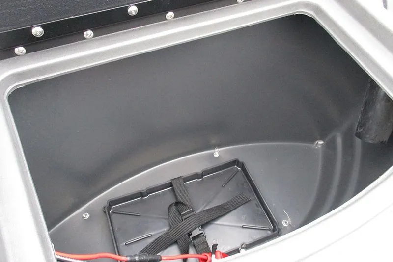 Slide: The Image of Storage compartment of 2026 Sun Tracker Bass Buggy 18 DLX boat, featuring secure battery holder. - 17