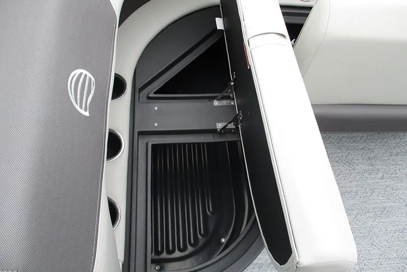 Slide: The Image of 2026 Sun Tracker Bass Buggy 18 DLX storage compartment with open seat and cup holders. - 24