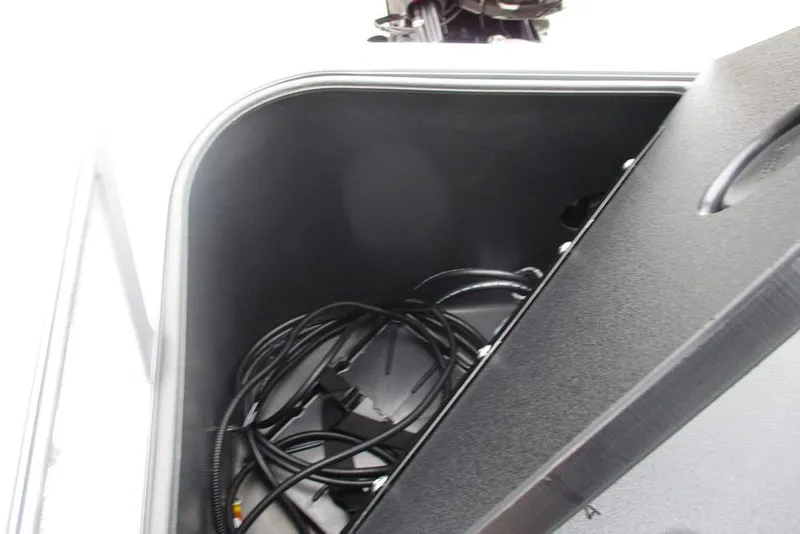 Slide: The Image of Storage compartment of 2026 Sun Tracker Bass Buggy 18 DLX with cables inside. - 27