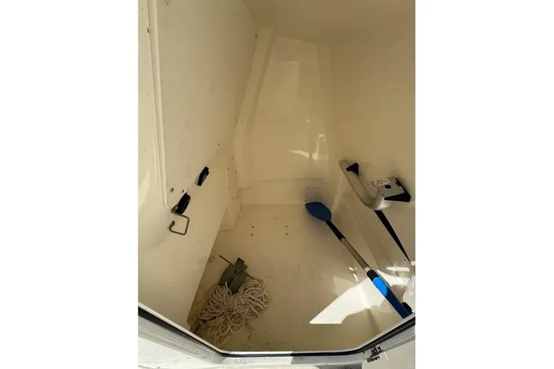 Slide: The Image of Interior storage compartment of 2022 Boston Whaler 220 Dauntless boat with equipment. - 10