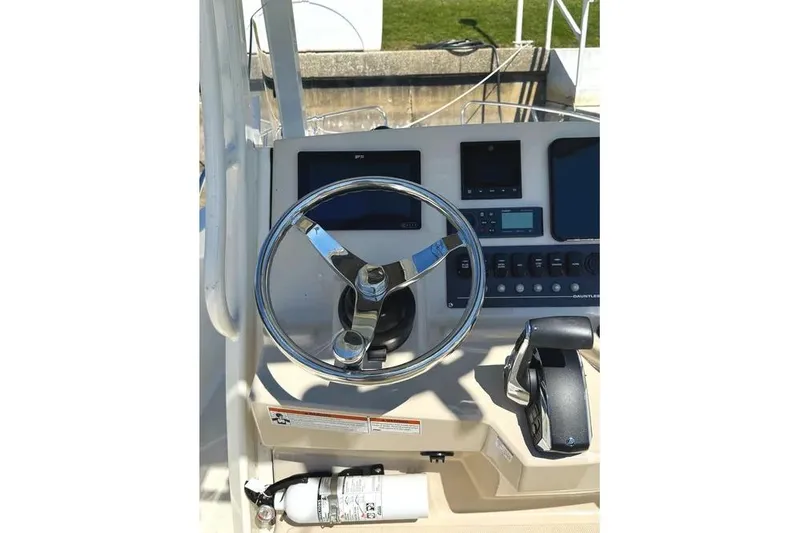 Slide: The Image of 2022 Boston Whaler 220 Dauntless helm with steering wheel and control panel. - 11