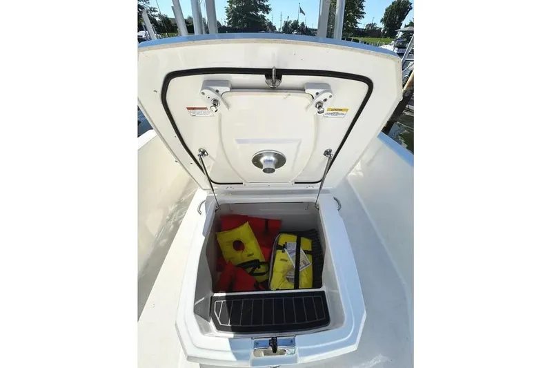 Slide: The Image of Open storage compartment on 2022 Boston Whaler 220 Dauntless, containing life jackets and safety gear. - 18