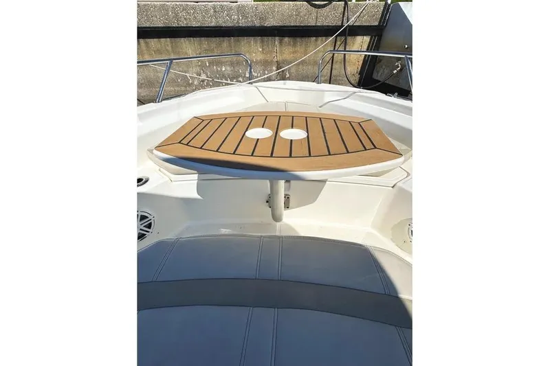 Slide: The Image of 2022 Boston Whaler 220 Dauntless boat interior with wooden table and seating. - 25
