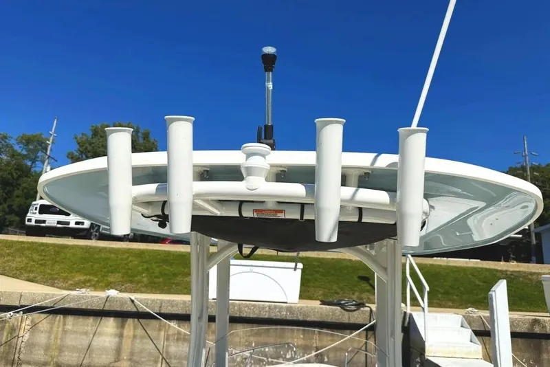 Slide: The Image of Boston Whaler 220 Dauntless 2022 boat with rod holders and antenna, docked under clear blue sky. - 27