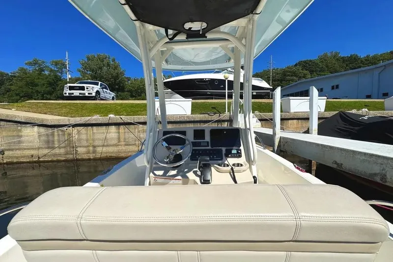 Slide: The Image of 2022 Boston Whaler 220 Dauntless at dock, featuring helm and seating area. - 3