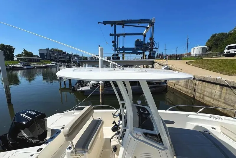 Slide: The Image of 2022 Boston Whaler 220 Dauntless boat docked at marina under clear blue sky. - 32