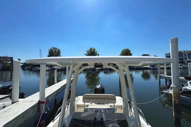 Slide: The Image of 2022 Boston Whaler 220 Dauntless docked at a marina under clear blue skies. - 33
