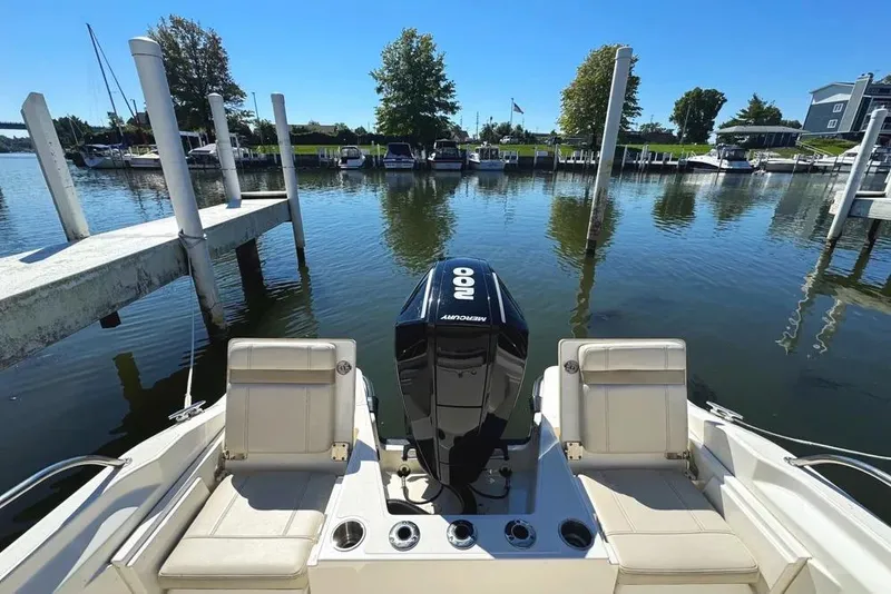 Slide: The Image of 2022 Boston Whaler 220 Dauntless boat docked, featuring a Mercury 200 engine. - 4