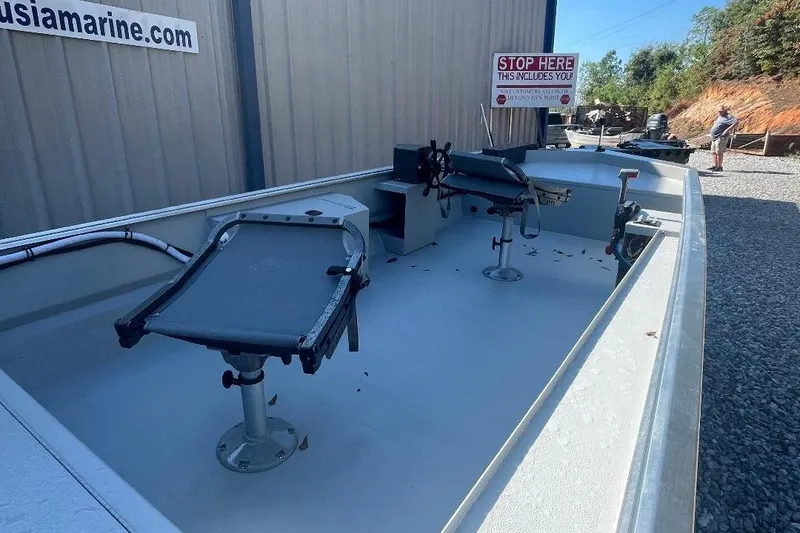 Slide: The Image of Custom 1660 PF boat, 2026 model, with seating and control area, parked outdoors. - 6