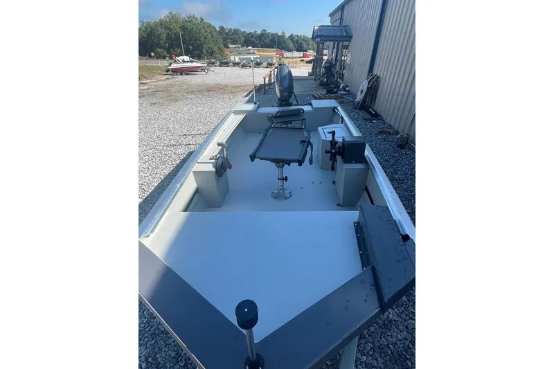 Slide: The Image of Custom 1660 PF boat, 2026 model, parked outdoors on gravel near a metal building. - 8