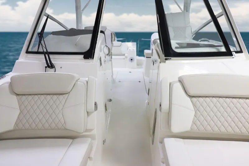 Slide: The Image of Manufacturer Provided Image: 2026 World Cat 325 DC boat interior with white seating and a wooden table, docked at marina. - 4