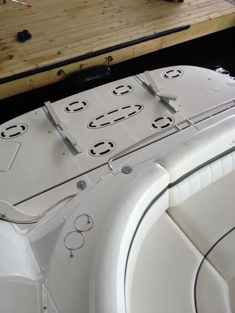 Slide: The Image of 2004 Sea Ray 500 Sundancer boat deck with white seating and wooden dock. - 14