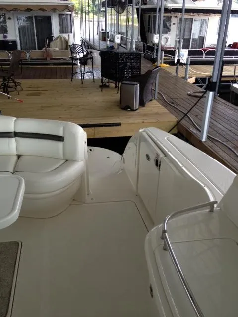 Slide: The Image of 2004 Sea Ray 500 Sundancer yacht interior with white seating and dock view. - 16