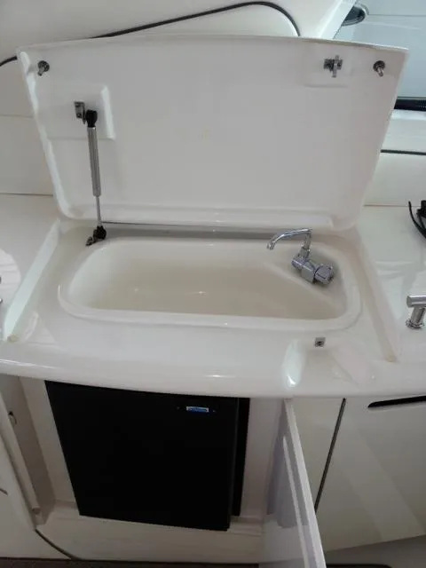 Slide: The Image of 2004 Sea Ray 500 Sundancer sink with open lid and faucet. - 19