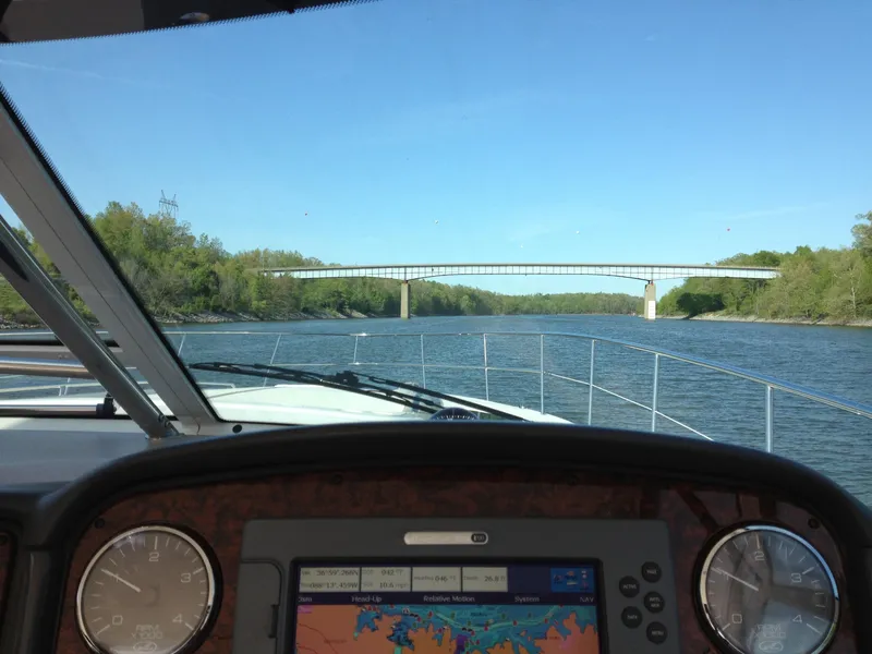 Slide: The Image of View from 2004 Sea Ray 500 Sundancer cockpit, navigating a river under a bridge. - 22