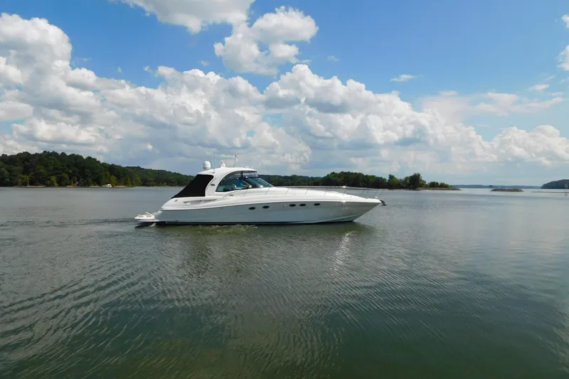 Slide: The Image of 2004 Sea Ray 500 Sundancer yacht cruising on a serene lake under a blue sky. - 30