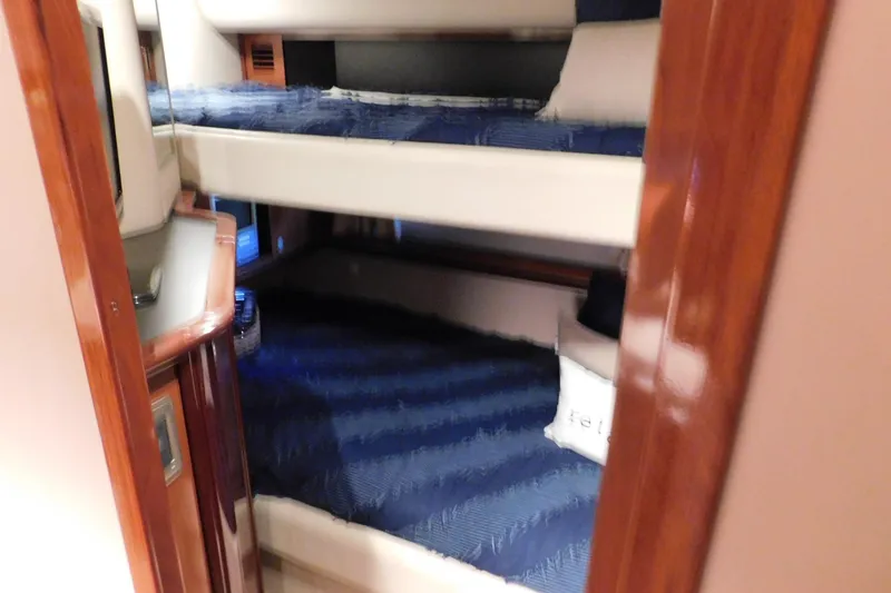 Slide: The Image of Interior of 2004 Sea Ray 500 Sundancer with cozy bunk beds and wooden accents. - 39