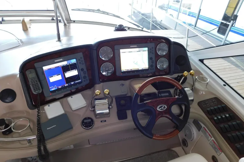 Slide: The Image of 2004 Sea Ray 500 Sundancer helm with navigation screens and steering wheel. - 41