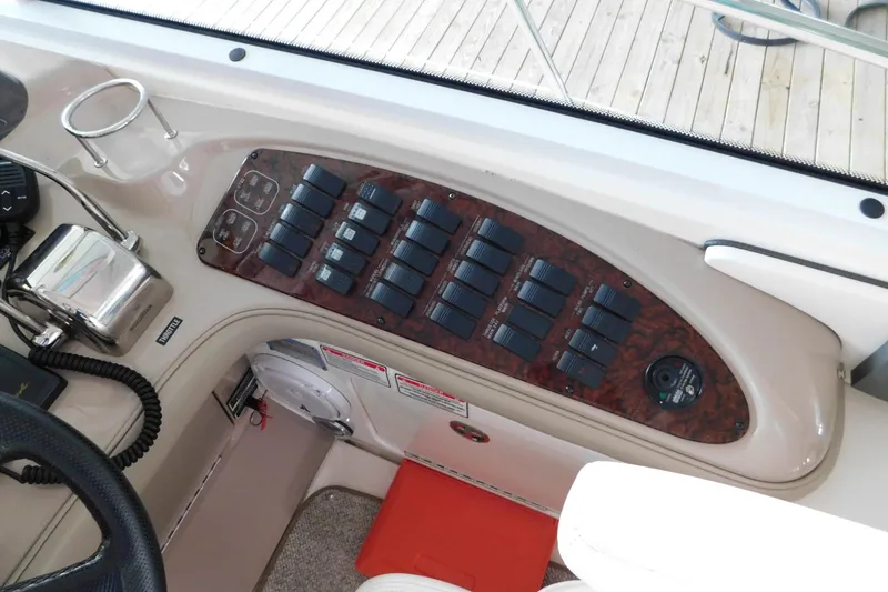 Slide: The Image of Control panel of a 2004 Sea Ray 500 Sundancer yacht with switches and throttle. - 43