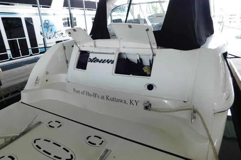 Slide: The Image of 2004 Sea Ray 500 Sundancer docked, rear view with open storage compartments. - 67