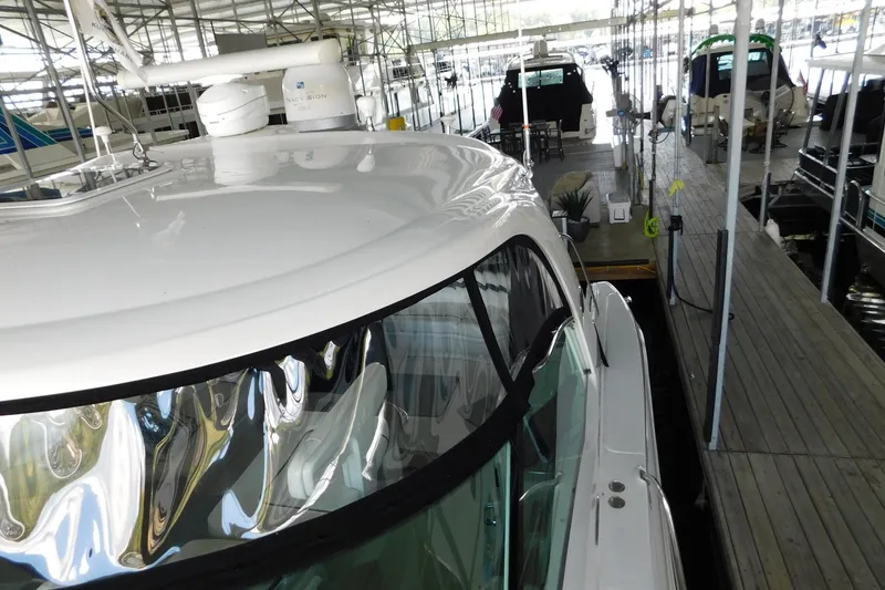 Slide: The Image of 2004 Sea Ray 500 Sundancer yacht docked in a marina, showcasing sleek design and spacious deck. - 71