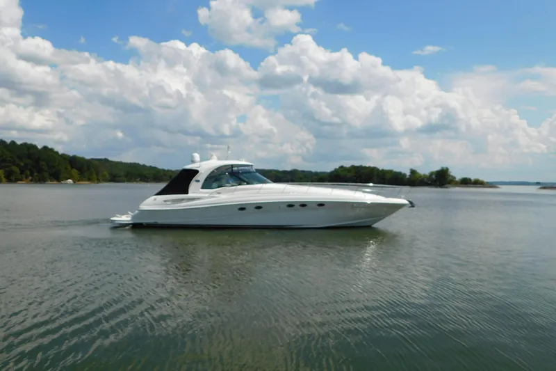 Slide: The Image of 2004 Sea Ray 500 Sundancer yacht cruising on a serene lake under a partly cloudy sky. - 72