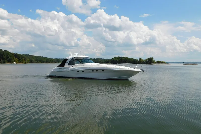 Slide: The Image of 2004 Sea Ray 500 Sundancer yacht cruising on a serene lake under a partly cloudy sky. - 73