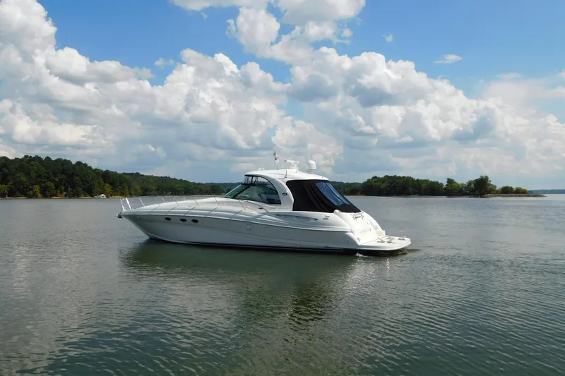 Slide: The Image of 2004 Sea Ray 500 Sundancer yacht on calm water under a partly cloudy sky. - 77