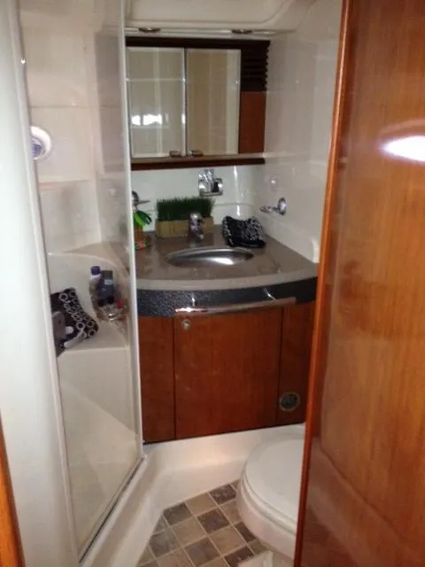 Slide: The Image of 2004 Sea Ray 500 Sundancer bathroom with wood cabinetry, sink, and shower. - 9