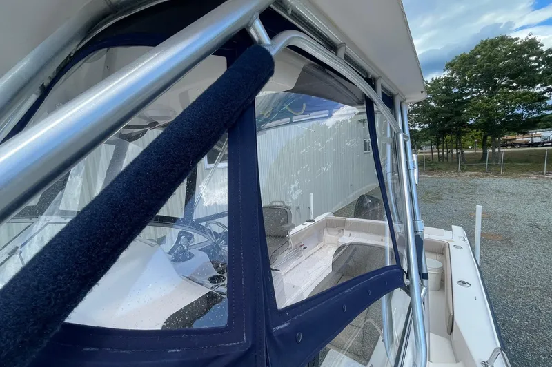 Slide: The Image of 2001 Grady-White Sailfish 255 boat with blue canvas enclosure and stainless steel frame. - 13