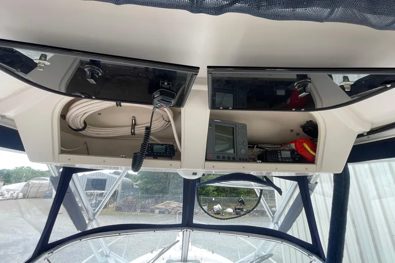 Slide: The Image of 2001 Grady-White Sailfish 255 boat dashboard with navigation equipment and storage compartments. - 23