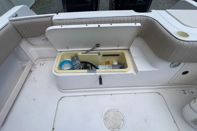 Slide: The Image of 2001 Grady-White Sailfish 255 boat storage compartment with open lid, revealing various items. - 27