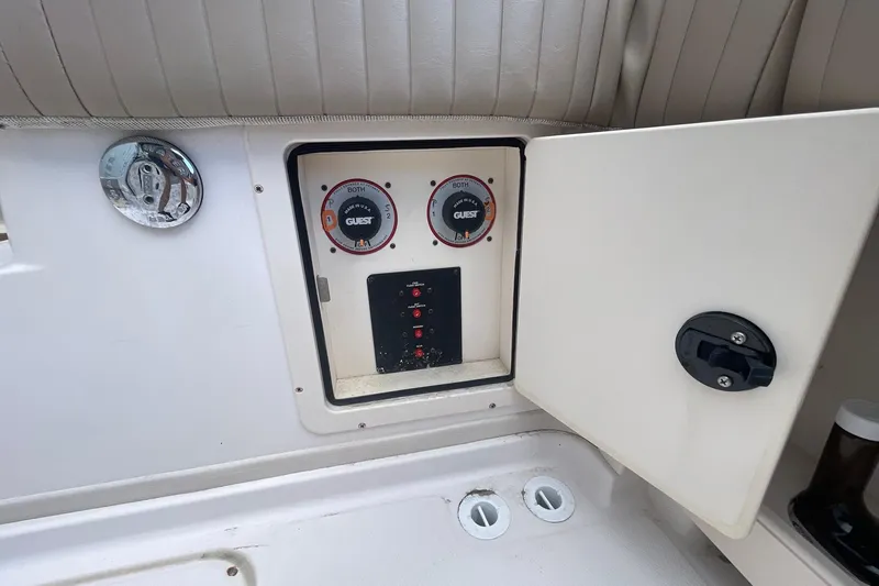 Slide: The Image of 2001 Grady-White Sailfish 255 boat control panel with open compartment and switches. - 28