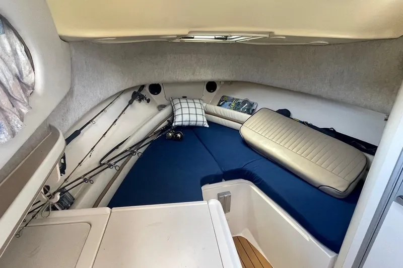 Slide: The Image of 2001 Grady-White Sailfish 255 cabin interior with fishing rods and blue cushions. - 30