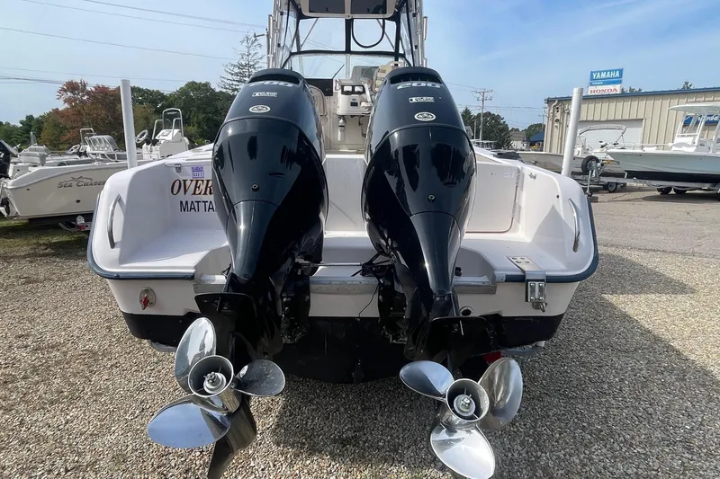 Slide: The Image of 2001 Grady-White Sailfish 255 with dual outboard motors, parked on gravel. - 4